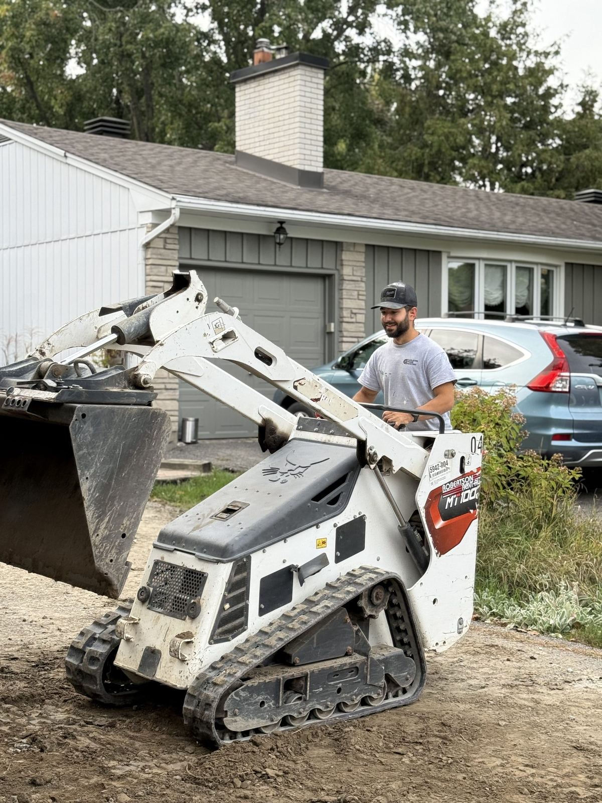 Carleton Prime team member preparing a site with a compact track loader