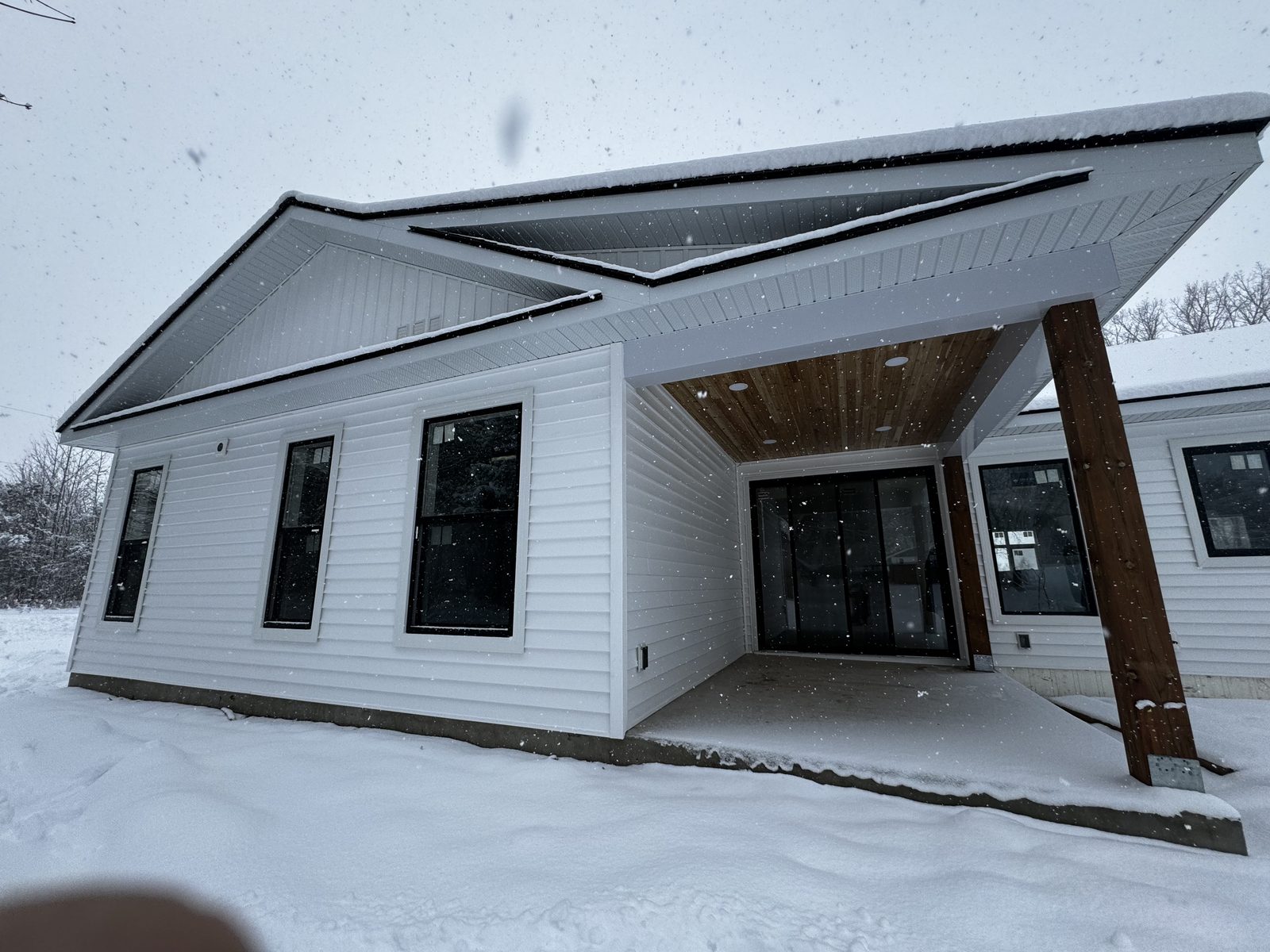 Covered entry porch with a timber post on a new custom home