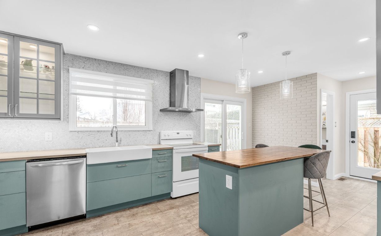 Kitchen remodel in Ottawa with sage-green cabinets, a butcher-block island and a farmhouse sink