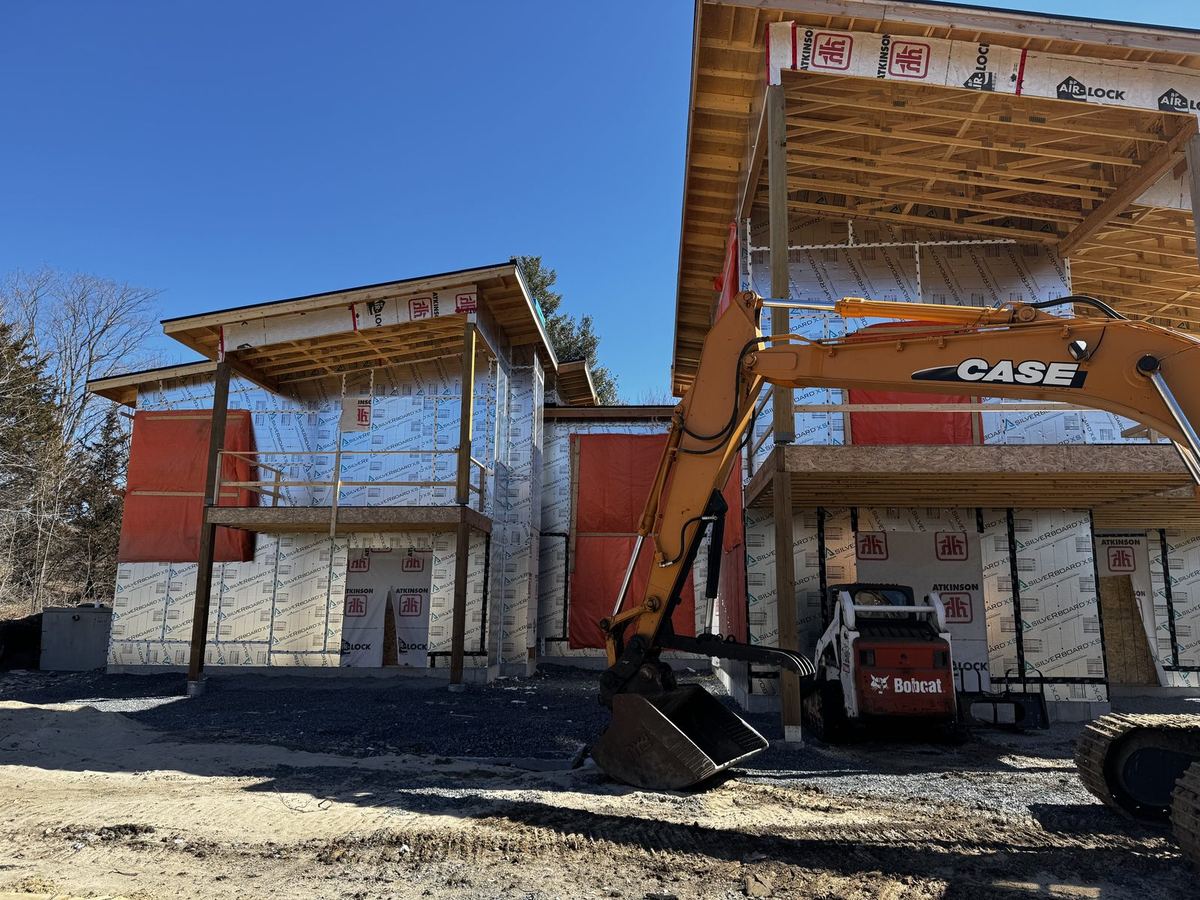 Site work and grading around a two-storey custom home under construction