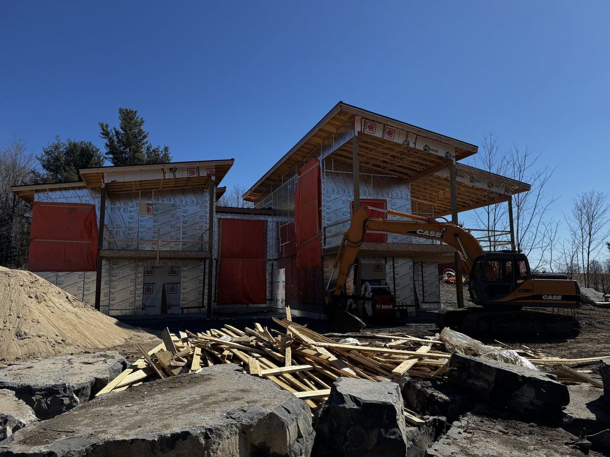 Two-storey modern custom home with timber overhangs during construction