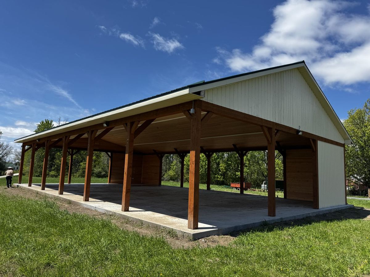Open timber pavilion with exposed posts and beams on a concrete slab